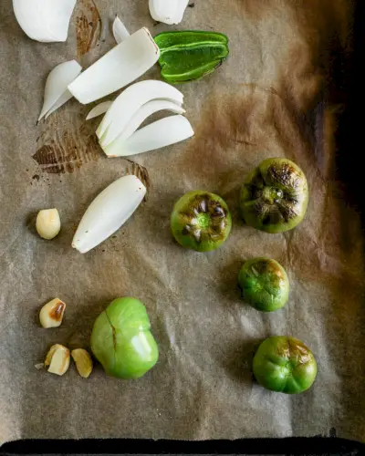 Grüne Tomaten und Zwiebeln auf Backblech