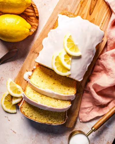 Plan aérien d'une recette de pain au citron avec glaçage et tranches de citron.