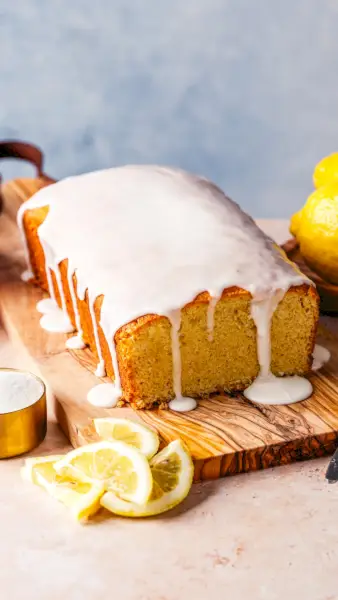 Recette de pain au citron avec glaçage au citron, arroser sur une planche à découper avec des tranches de citron.