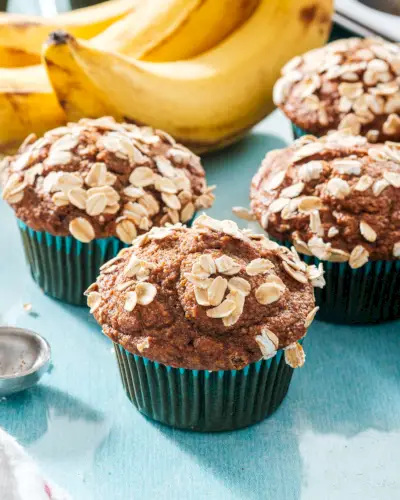 Muffins à la banane sains avec flocons d'avoine sur le dessus et bananes en arrière-plan