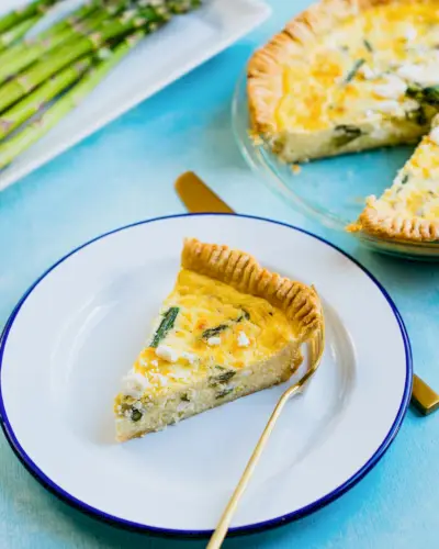 Spargel-Quiche mit einer Gabel in Scheiben schneiden.