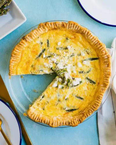 Spargelquiche in Kuchenform mit Feta-Käse garniert.
