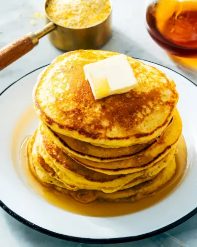 Crêpes à la semoule de maïs avec semoule de maïs dans une tasse en arrière-plan