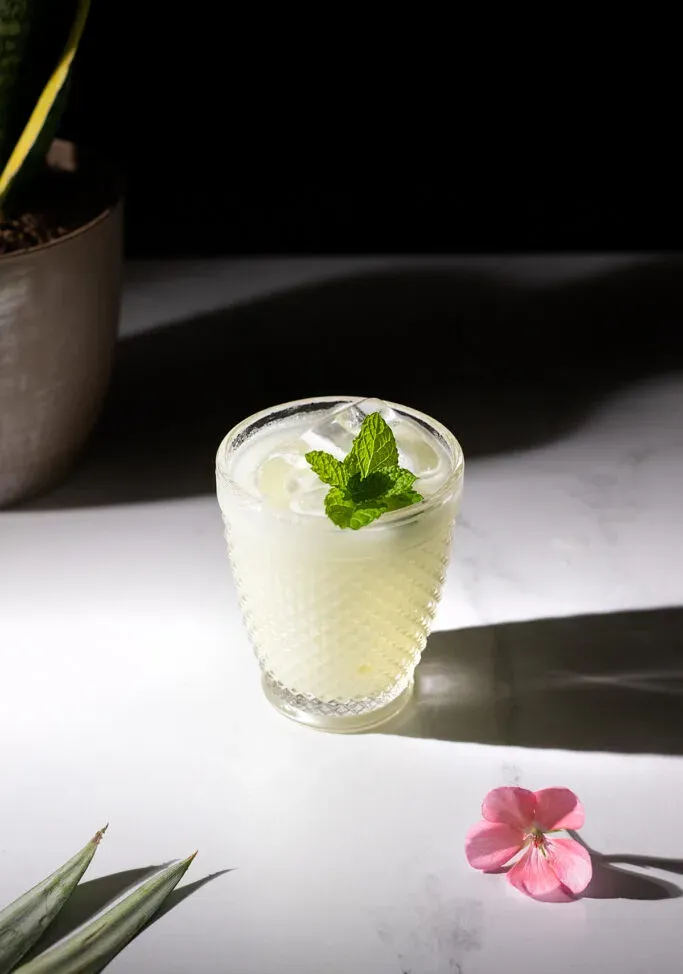pina verde w kieliszku typu rocks z miętą i kwiatem.' loading='lazy' title=
