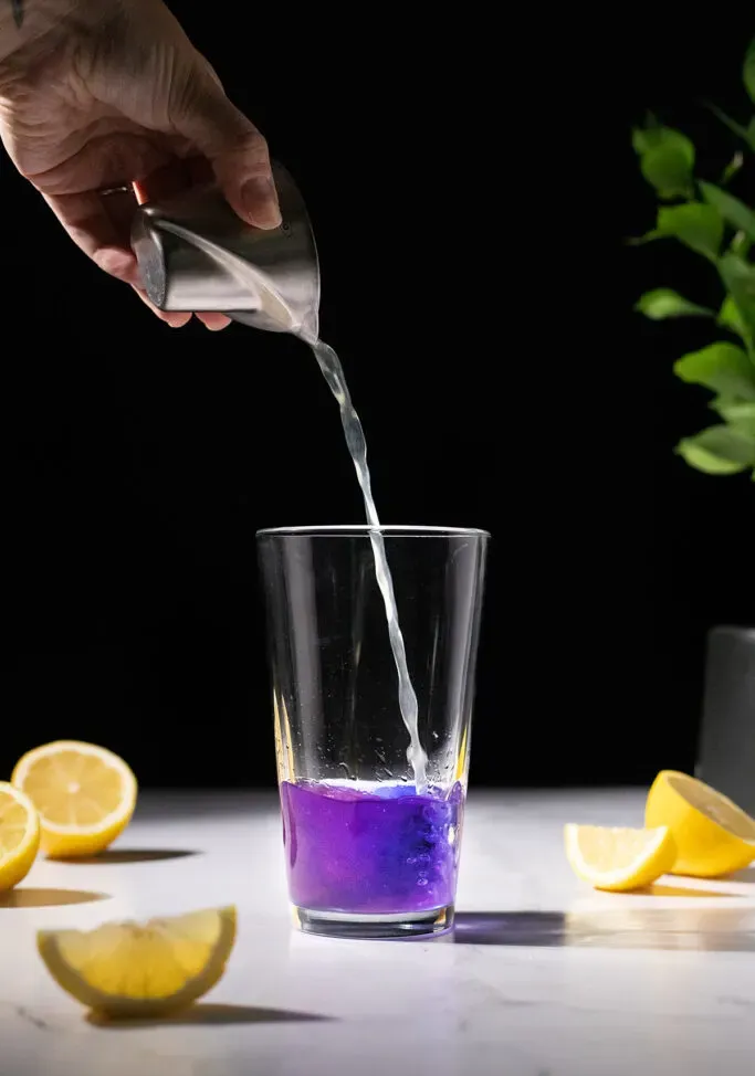 verter jugo de limón en Empress Gin haciendo que cambie de azul a rosa.' loading='lazy' title=