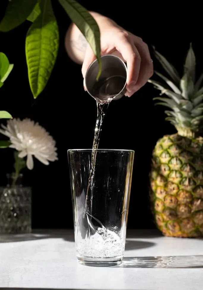 nalévání bílého rumu do koktejlového šejkru.' loading='lazy' title=