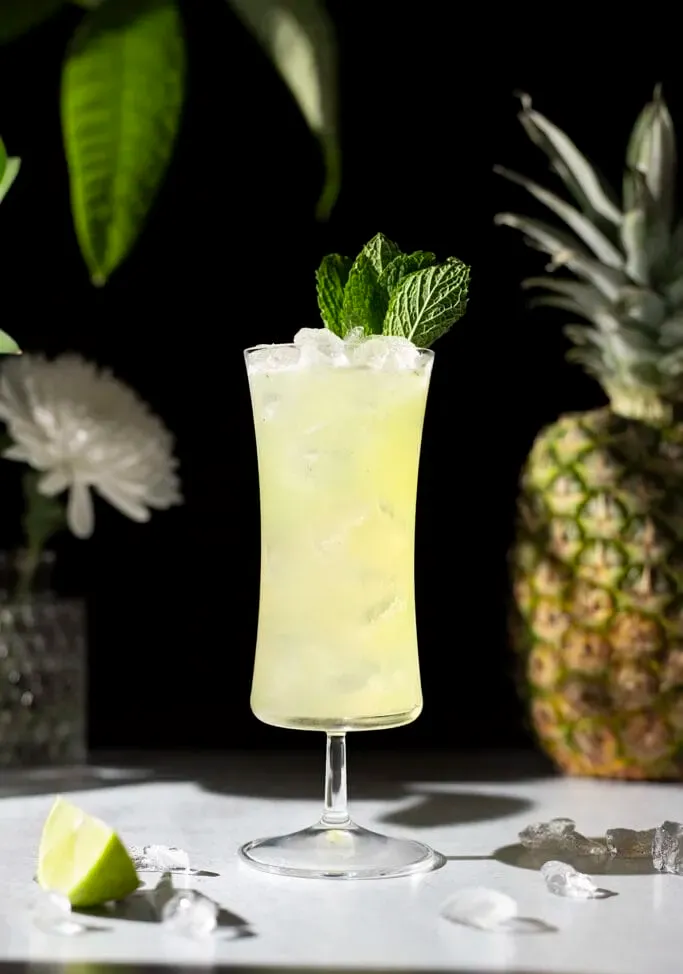 Koktejl Missionary’s Downfall zdobený lístky máty.' title=