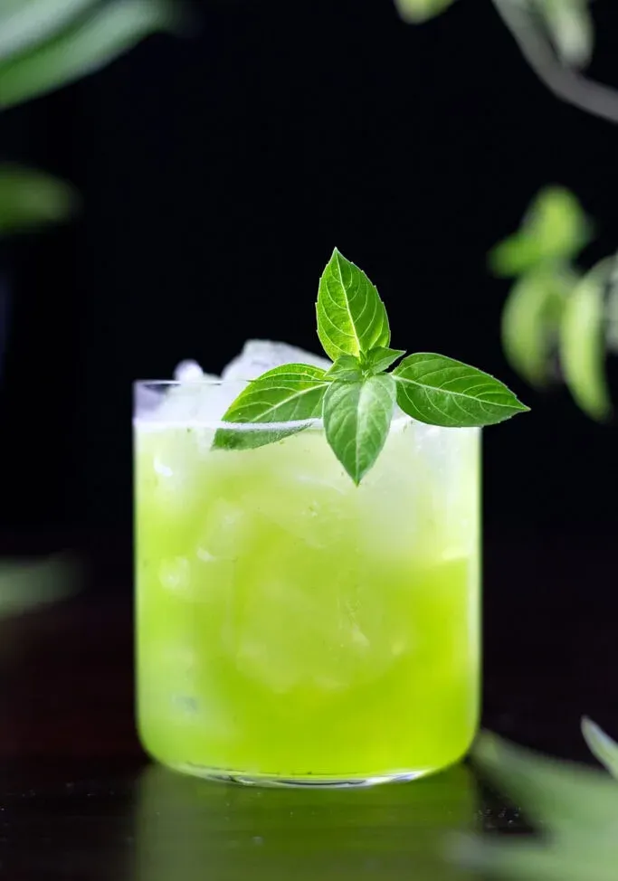 frantumare il basilico verde in un bicchiere rock con foglie di basilico.' loading='lazy' title=