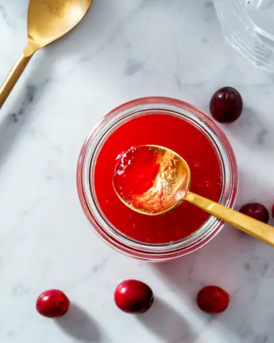 Cranberry-Sirup mit Löffel aus dem Glas