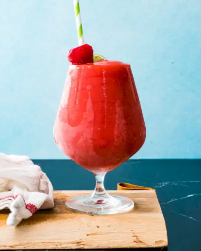 Recette de daiquiri aux fraises en verre avec garniture de paille et de fraise.