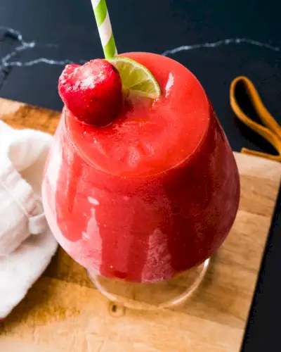 Daiquiri aux fraises surgelé avec garniture de citron vert et de fraise.