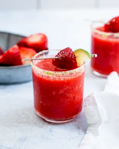 Margarita de morango em copo baixo com borda de sal e guarnição de morango