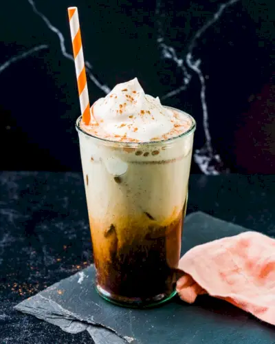 Iced Pumpkin Spice Latte v šálke s oranžovou pásikavou slamkou