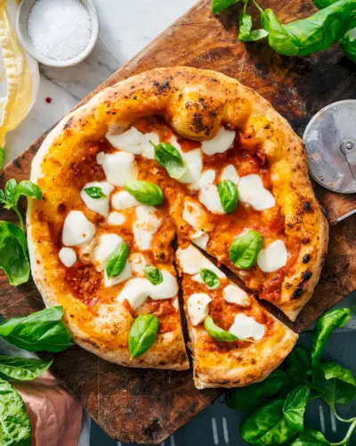 Pizza Margherita com molho de pizza e cortador de pizza.