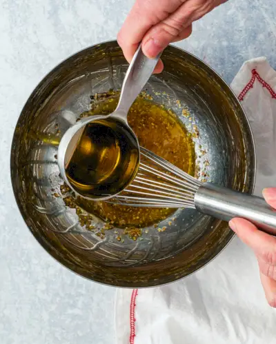 Condimento per insalata greca passo 2: aggiungere gradualmente l'olio d'oliva.