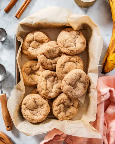 Cookies de banana em uma bandeja com bananas e paus de canela