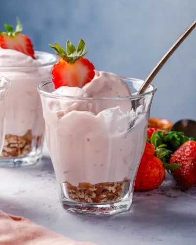 Rezept für Erdbeermousse in einer Tasse mit zerkleinerten Brezeln.