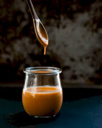 Löffel schwebt über einem mit Chipotle-Sauce gefüllten Glas