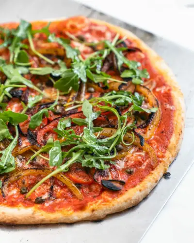 Gesunde Pizza mit dünner Kruste auf Pizzaschieber.