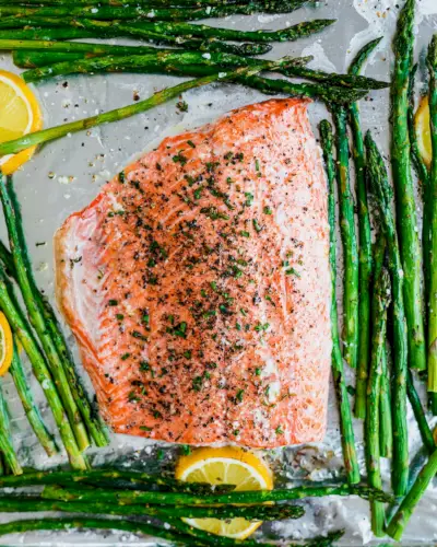 Saumon et asperges sur une plaque avec des tranches de citron.