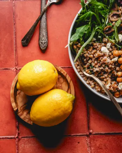 Limones en plato con tazón de grano de farro