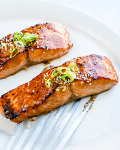 Receita de salmão missô com guarnição de cebola verde.