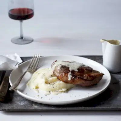 Côtelettes de porc braisées au lait avec purée de pommes de terre et sauce