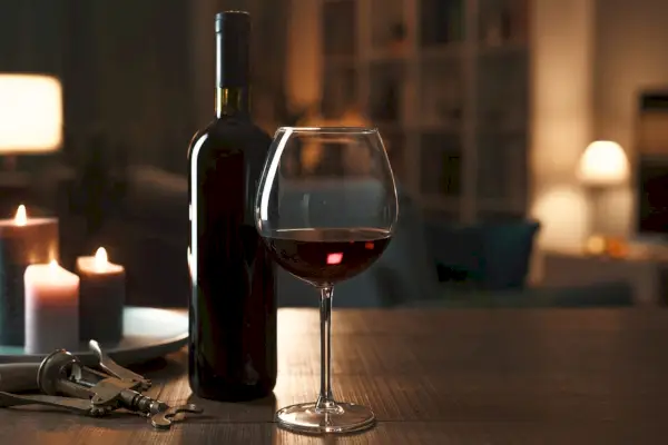 Uma garrafa e um copo de vinho tinto