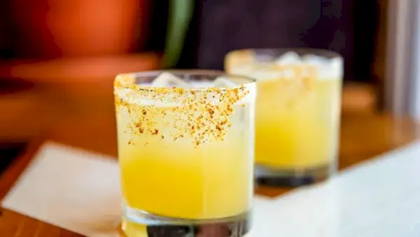 Gelber Honey-Trap-Cocktail mit einem Rand, der mit Bienenpollen gesalzen ist