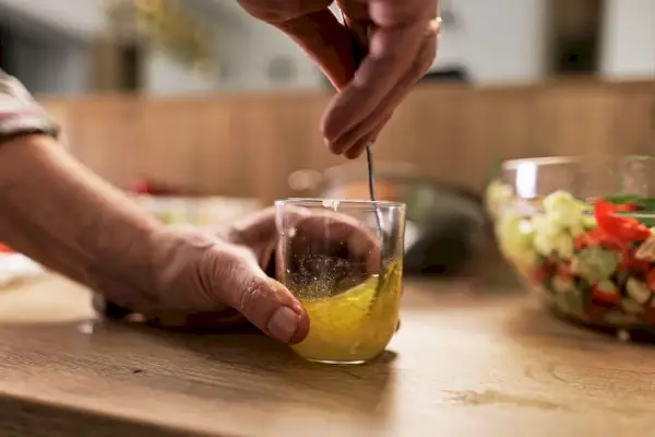 Človek si namieša čerstvý vinaigrette