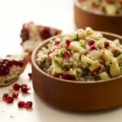 Salada de cevada perolada com maçãs, sementes de romã e pinhões