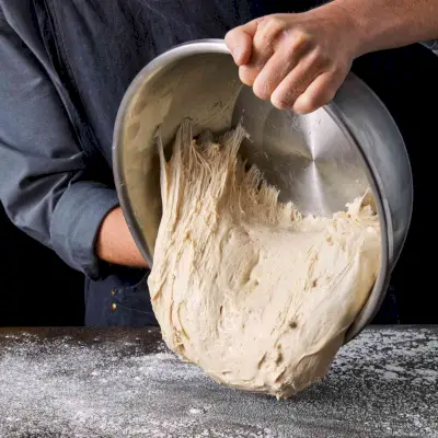 girare l'impasto della pizza su una superficie infarinata