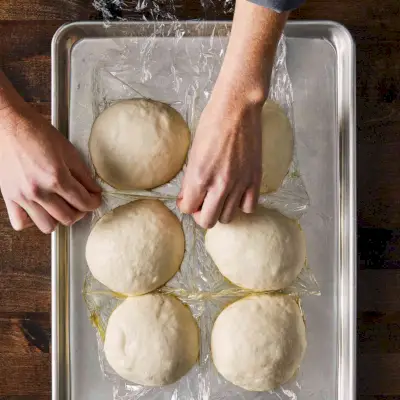 Palline di pasta per pizza su teglia oliata e rivestita in plastica