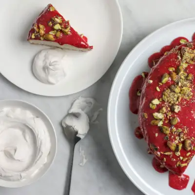 Kokosmilchkuchen mit Pistazien, geschlagener Kokoscreme und Erdbeerglasur