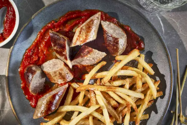 Currywurst a hranolky na šedém talíři střílel shora.