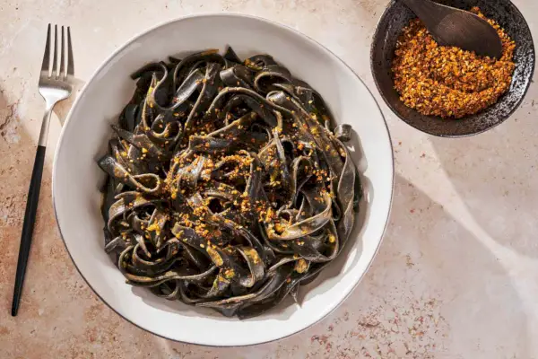 Schüssel mit Tintenfischnudeln mit Uni-Butter und kleine Schüssel mit Sukkah