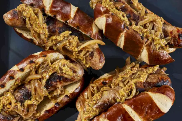 Bratwurst mit Belag im Laugenbrötchen.