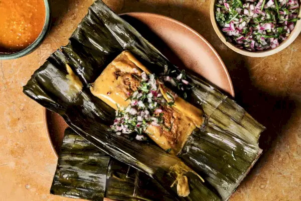 Tamales de pierna de cordero envueltos en hojas de plátano con salsa de chile morita
