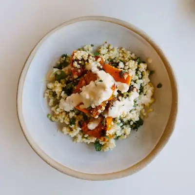 Mit Gewürzen gerösteter Butternusskürbis mit Kräuterhirse und Tahini-Dressing