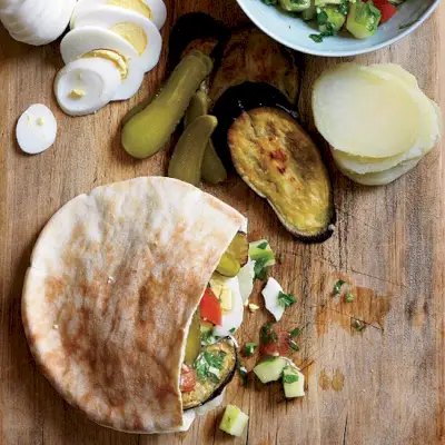 Sándwiches israelíes de berenjena asada, hummus y pepinillos