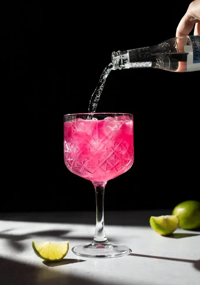 핑크색 음료에 토닉 워터를 붓는다' title=