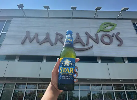 person holding beer in front of mariano