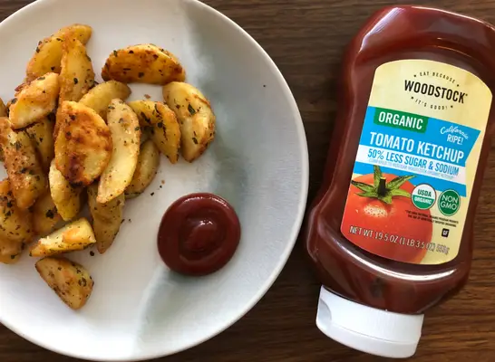 woodstock ketchup bottle with ketchup and fries on a plate.