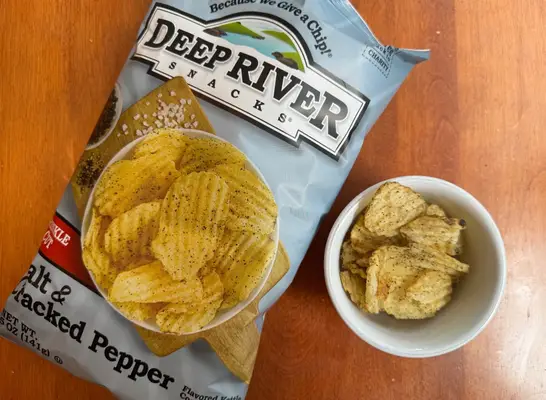 deep river chips in a bag and a bowl on a table.