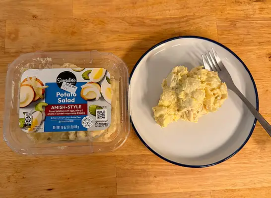 a container of potato salad next to a dish of potato salad