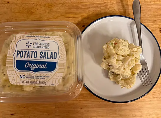a container of walmart potato salad next to a dish of potato salad