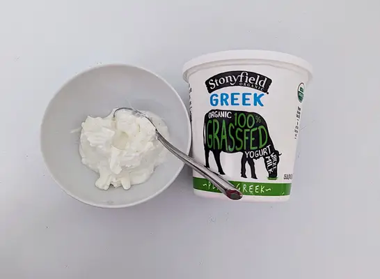 stonyfield greek yogurt in a bowl and a container.