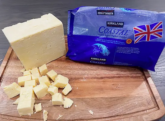 a block of kirkland coastal cheddar ona cutting board