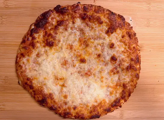 a gluten free cheese pizza on a cutting board.