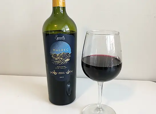 a bottle of malbec next to a glass of red wine